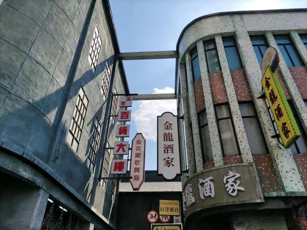 Dynamic shot of urban buildings with prominent Asian signage and architectural details.